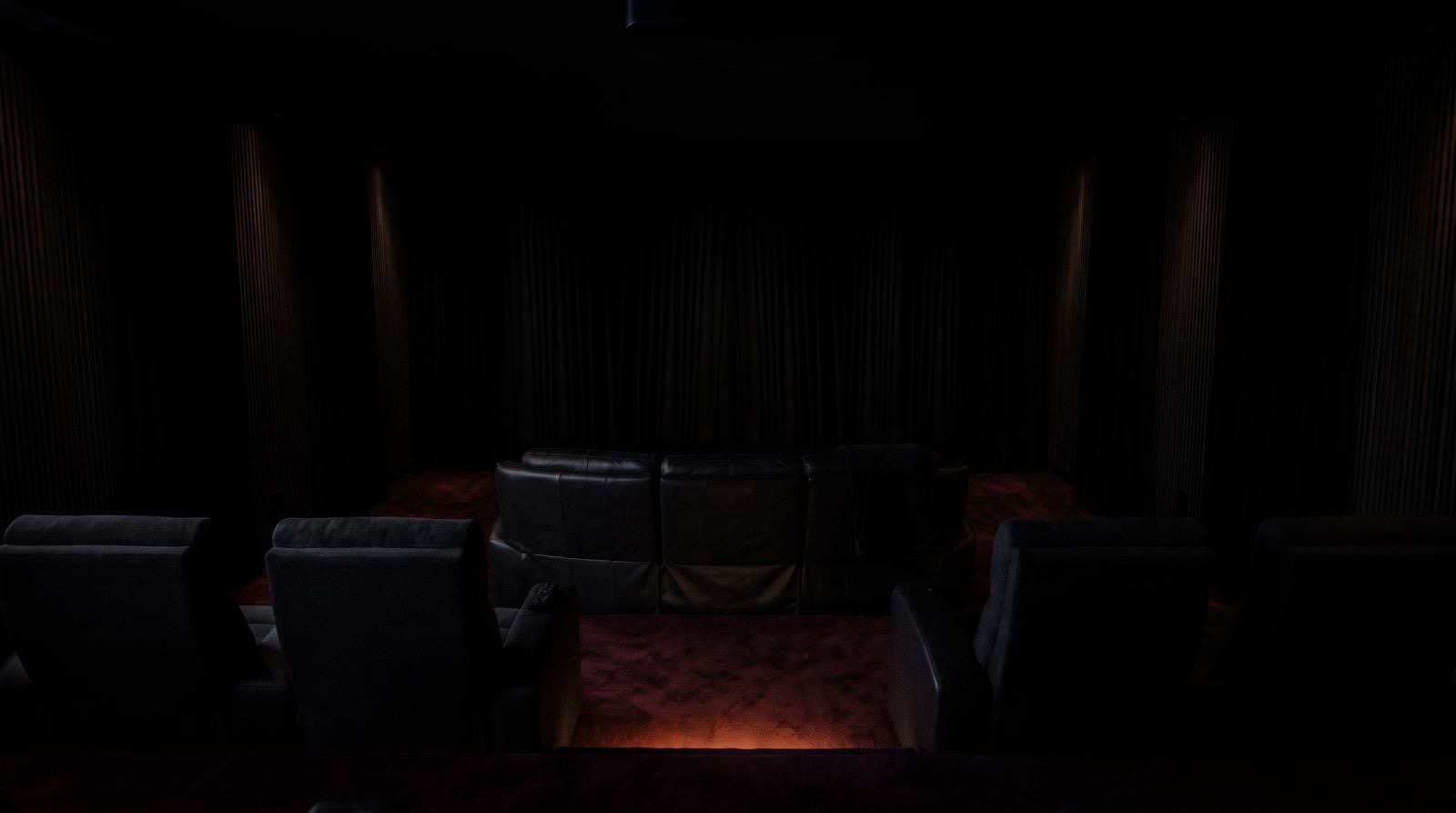 Heimkino im Ruhemodus: der schwarze Samtvorhang ist vor der Leinwand zugezogen, Licht und Beamer aus, nur das Stufenlicht glimmt (Symbolbild)